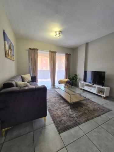 ein Wohnzimmer mit Sofa und Fernseher in der Unterkunft Mlangeni's Rest in Centurion