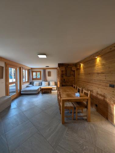 una sala de estar con una mesa y un sofá en Appt de charme dans chalet - cosy & nature, en Villars-sur-Ollon