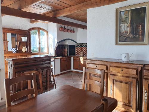 a kitchen with wooden cabinets and a table and chairs at La bastide du rousset in Ascros