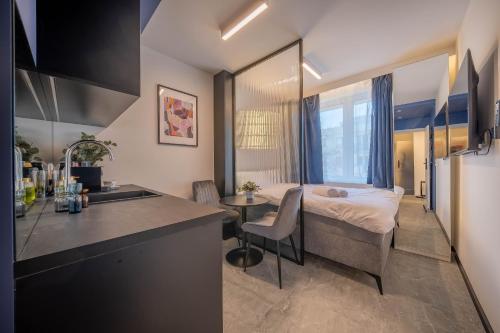 a kitchen and a bedroom with a bed in a room at Żurawia Mini Apartments by Sofija in Warsaw