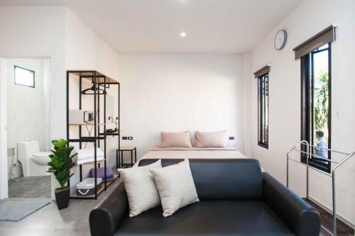 un salon avec un canapé et un lit dans l'établissement comfortable BAMBOO houses, à Ban Thalat Choeng Thale