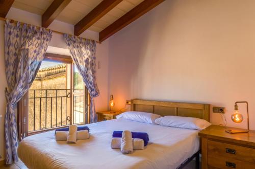 a bedroom with two beds and a window with a balcony at Son Pons in Llucmajor