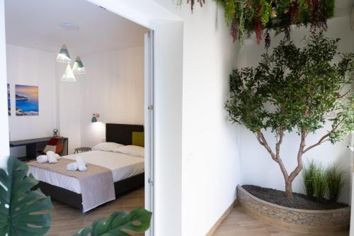 a bedroom with a bed and a tree in it at Adagos in Palermo