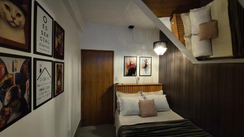 a bedroom with a bed and some pictures on the wall at Stúdio 7 climatizado, centro-terreo-privativo in Domingos Martins