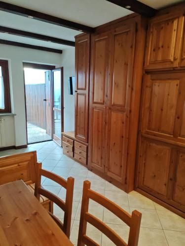 a dining room with wooden cabinets and a table at La Baita del Sagittario in Prato Nevoso
