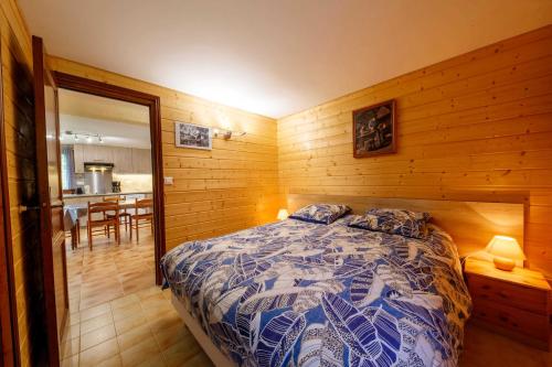 une chambre avec un lit dans une pièce en bois dans l'établissement Les jasmins, à Saint-Étienne-de-Tinée