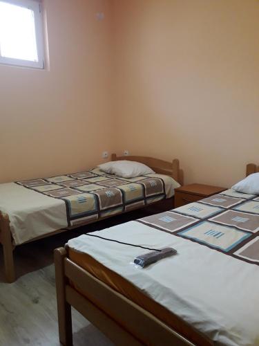a bedroom with two beds and a window at VILANATALIJA PANSION, APATIN in Apatin