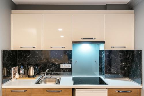 a kitchen with white cabinets and a sink at On4 Rooms & Suites in Istanbul