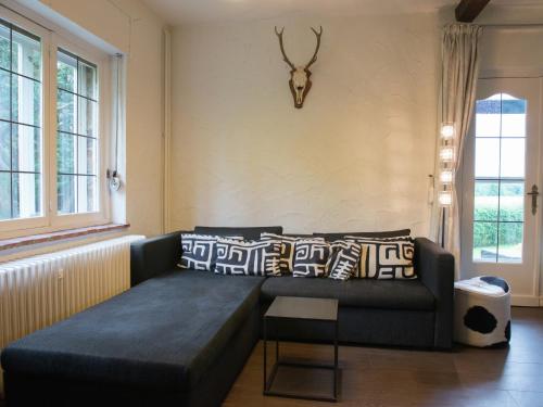 a living room with a couch and a antelope head on the wall at Mansion in Spa Liege with private garden in Spa