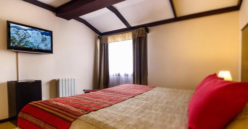 1 dormitorio con 1 cama y TV de pantalla plana en Hotel Michelangelo en El Calafate