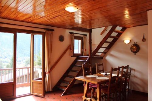a dining room with a wooden staircase and a table at Chez memene in Valdeblore