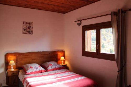 a bedroom with a bed with two lamps and a window at Chez memene in Valdeblore