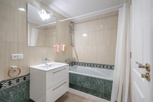 Un baño con lavabo, bañera y ducha. en Apartament Miramar, en Alcanada