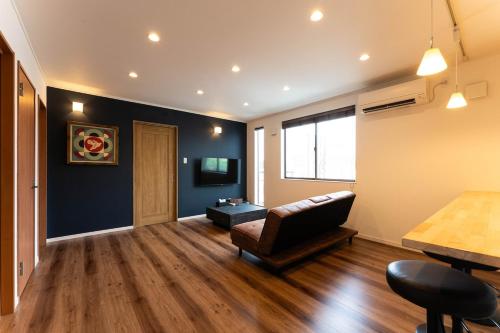 a living room with a couch and a table at Dekoboko inn西本町 in Omura