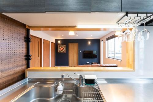 a kitchen with a sink and a mirror at Dekoboko inn西本町 in Omura