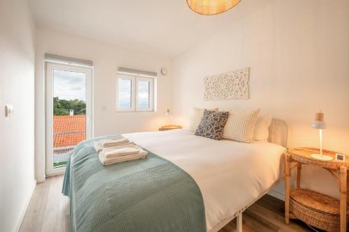 a bedroom with a large white bed with a window at Guest Ready - Charming Retreat in Palmela in Palmela