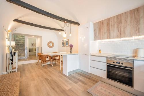 a kitchen with white cabinets and a dining room with a table at Guest Ready - Charming Retreat in Palmela in Palmela