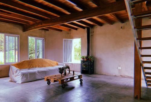 a living room with a bed and a table at El Ventanal in Las Rabonas