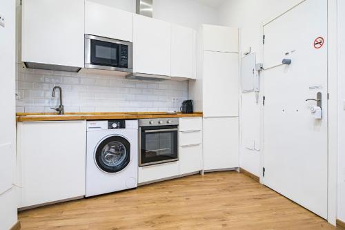 a white kitchen with a washing machine in it at NOMADIA en LARIOS STREET in Málaga