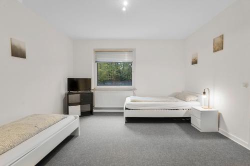 ein weißes Zimmer mit zwei Betten und einem Fenster in der Unterkunft Apartment in Celle for Business Traveler in Celle