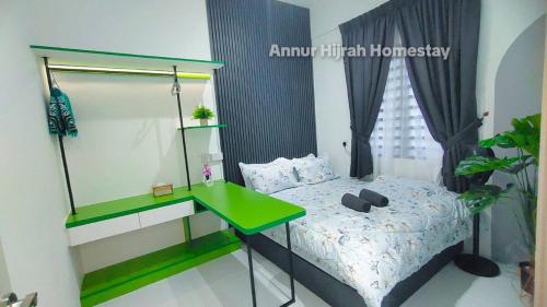斯里伊斯兰德Homestay Annur Hijrah Seri Iskandar Near UiTM ,UTP的带绿色书桌和床的卧室