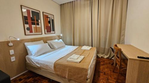 une chambre avec un lit avec deux serviettes dessus dans l'établissement Refúgio Aconchegante na Cidade, à Campinas