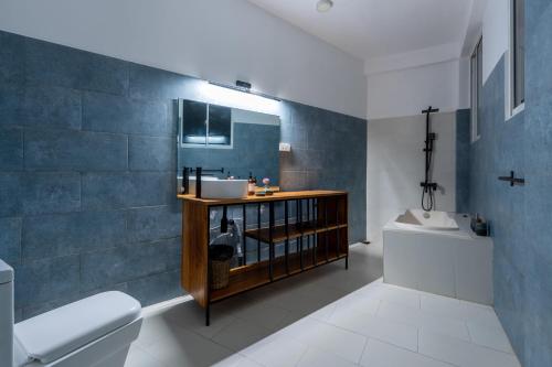 a bathroom with a sink and a toilet at Hebron Gardens House in Kandy