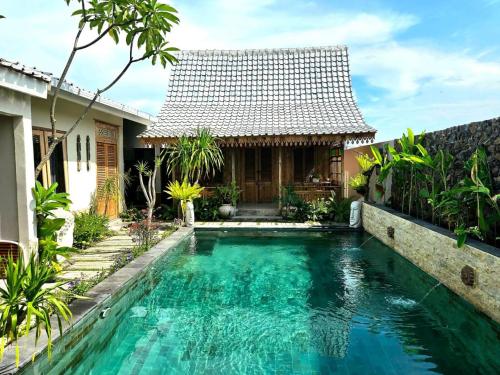 ein Swimmingpool vor einem Haus in der Unterkunft Villa Soluna Lovina in Lovina