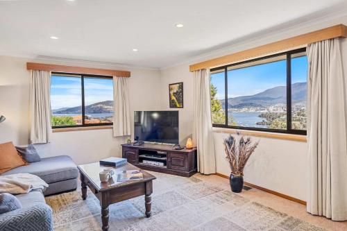 - un salon avec un canapé, une télévision et des fenêtres dans l'établissement The Lookout with City water and Mountain views, à Bellerive
