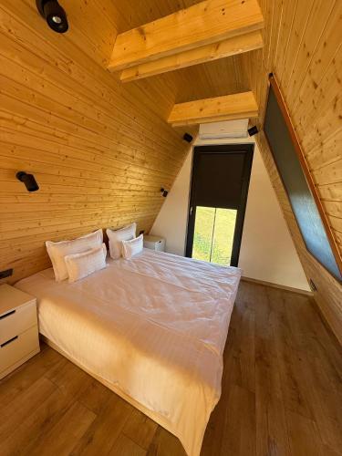 a bedroom with a bed in a wooden room at Vatra Barsei in Tohanu Nou