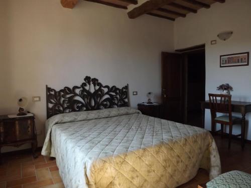 a bedroom with a bed and a table and a chair at La Corte Del Daino in Mercatello