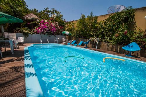 a large swimming pool with blue chairs and umbrellas at Hotel Borari in Alter do Chao