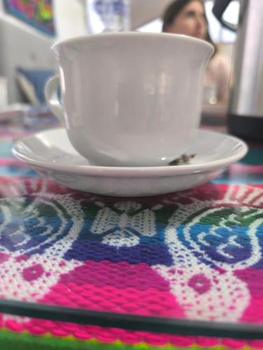 a white cup on a plate on a table at Mary Titicaca lodge uros in Puno