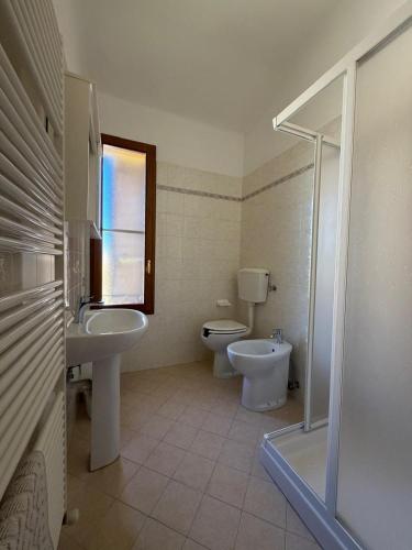 a bathroom with a sink and a toilet and a window at Molinella Appartamento Amelia & Carlo in Molinella