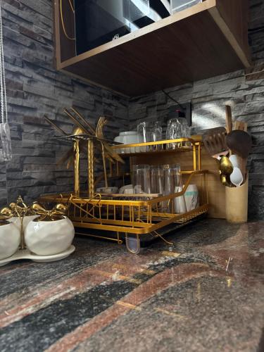 a kitchen with a shelf with dishes and utensils at Suite Nothings in Kampala