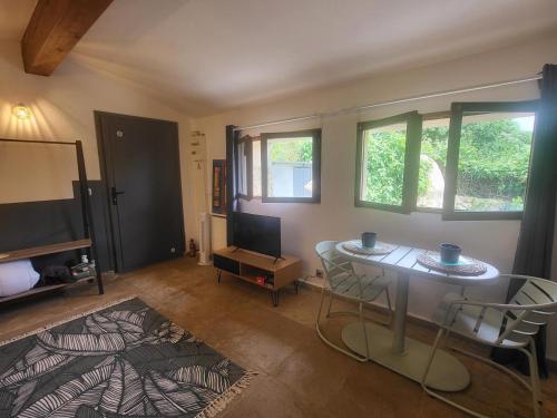 a living room with a table and chairs and a bed at L'ombre du vent in Contes