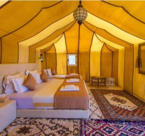 a bedroom with a bed in a tent at Desert cmp luxury in Merzouga