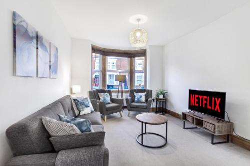 a living room with a couch and a tv at Home Away I 3BR Comfort Suite I Private Courtyard I Super Fast Wi-Fi I Free Parking in Bedford