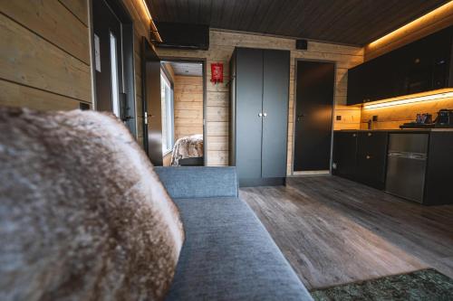 a living room with a couch and a kitchen at Aurora Hill Resort, Rovaniemi in Rovaniemi