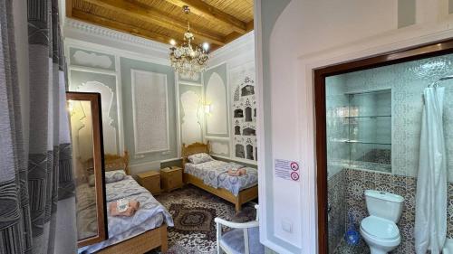 a bathroom with two twin beds and a shower at Rahmat guesthouse in Bukhara