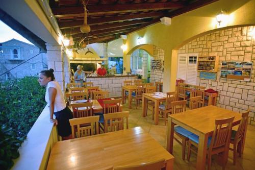 a woman standing in a restaurant with tables and chairs at Apartments with a parking space Hvar - 3229 in Hvar