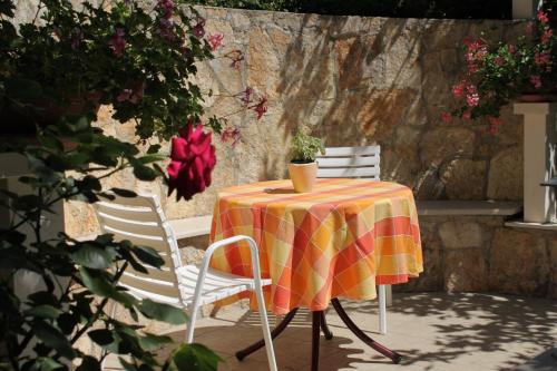 a table with two chairs and a table with a tablecloth at Apartments by the sea Tucepi, Makarska - 6806 in Tučepi