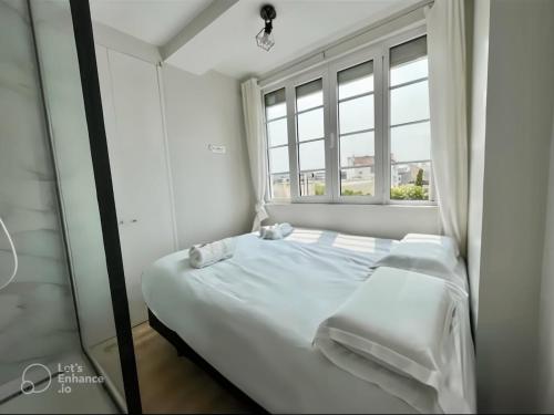 un lit blanc dans une chambre avec une fenêtre dans l'établissement Exceptional apartment near Parc des Princes, à Boulogne-Billancourt