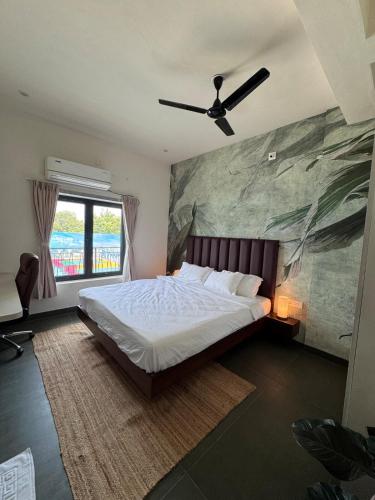 a bedroom with a bed and a ceiling fan at Turiya Retreat in Auroville