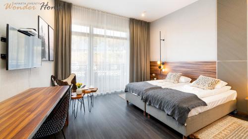 a bedroom with a large bed and a wooden table at Wonder Hill - bajkowy widok na góry i zalew, dostęp do basenów i jacuzzi in Sosnówka