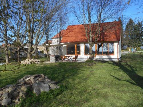 uma casa com um telhado vermelho num jardim verde em Apartmán Na Váze em Jindřichŭv Hradec