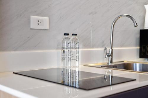 dos botellas de agua sentadas en un mostrador junto a un fregadero en Wyndham Gardens 1320 Studio 1m from Naithon Beach, en Nai Thon Beach
