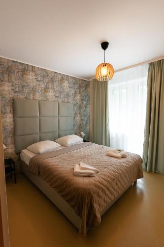 a bedroom with a large bed with two towels on it at Ośrodek Wypoczynkowo-Rehabilitacyjny Perła Borów in Tleń