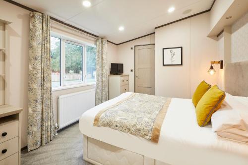 une chambre avec un grand lit et une fenêtre dans l'établissement Brackencroft Lodge with Hot Tub, à York