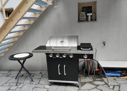 布拉格Prague Luxury Apartment的厨房里有炉灶和凳子，旁边是楼梯。